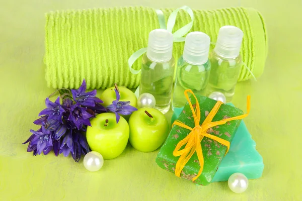 Ručně vyrobené mýdlo a aroma svíčky na zelené dřevěné pozadí — Stock fotografie