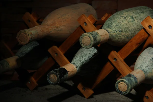 Oude flessen wijn in oude kelder, op donkere achtergrond — Stockfoto
