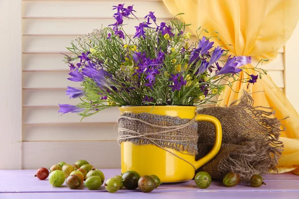 Güzel Kupası ve ahşap masa üzerinde meyveleri kır çiçekleri buketi — Stok fotoğraf