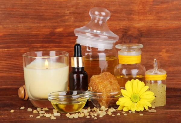 Fragrant honey spa with oils and honey on wooden table on wooden background — Stock Photo, Image