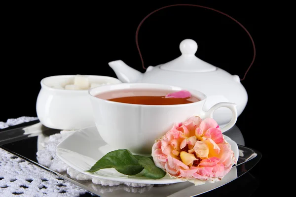 Tetera y taza de té de rosa de té en bandeja metálica sobre fondo negro servilleta — Foto de Stock