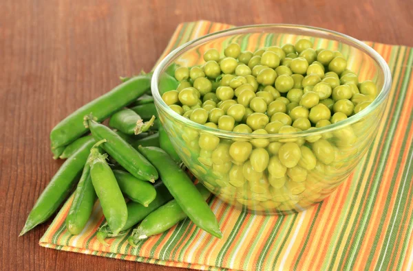 Guisantes verdes sobre fondo de madera — Foto de Stock