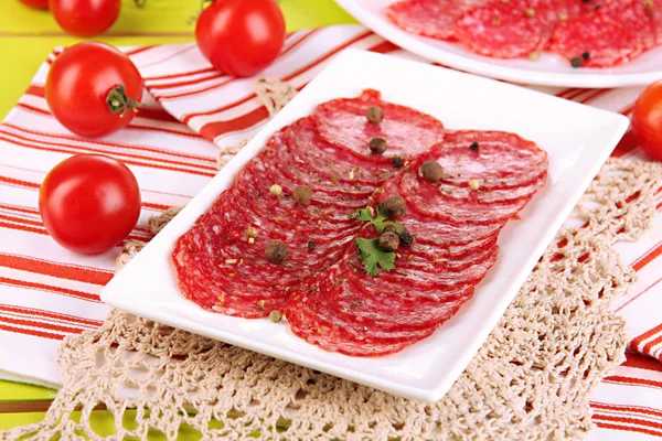 Savoureux salami sur assiettes sur table en bois close-up — Photo