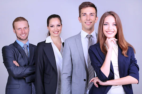 Zakelijke team staande in rij op grijze achtergrond — Stockfoto