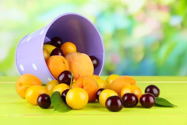 Doğal zemin üzerine ahşap masa üstünde kova içinde parlak yaz meyve — Stok fotoğraf