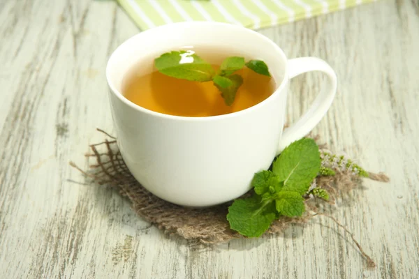 Xícara de chá de ervas com hortelã fresca na mesa de madeira — Fotografia de Stock
