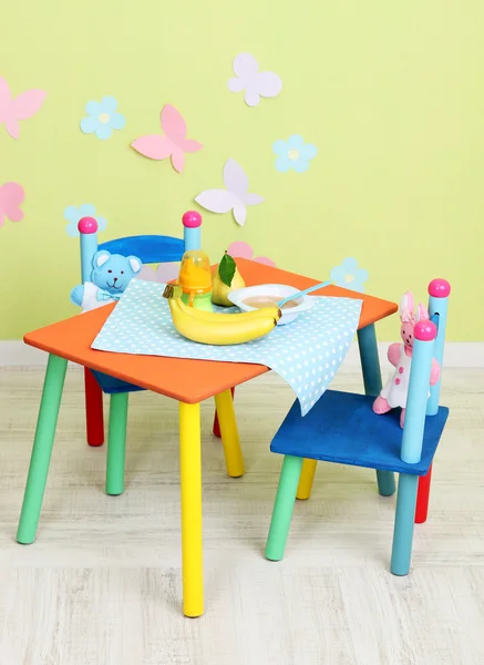 Tasty baby fruit puree and baby bottle on table in room — Stock Photo, Image