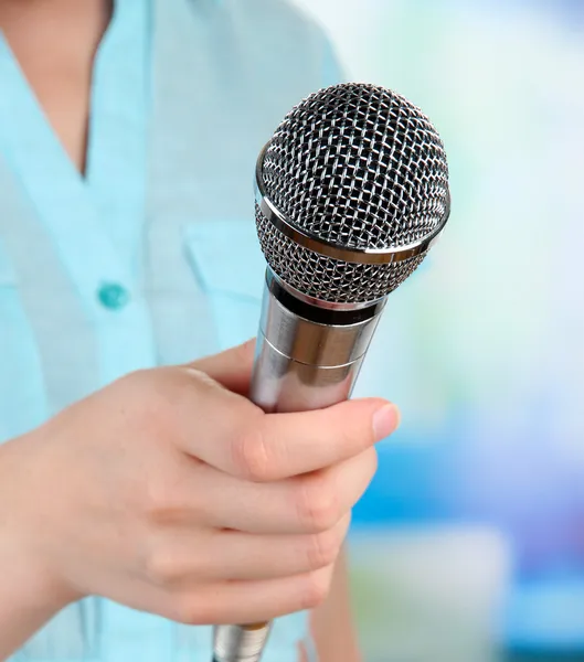 Femme avec microphone sur fond de pièce — Photo