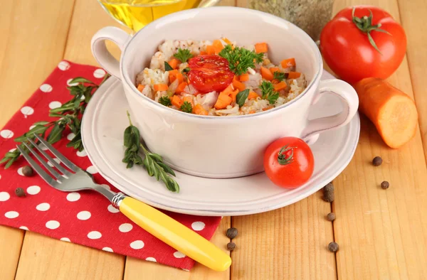 Delicious rice with vegetables and herbs in pot on wooden table close-up — Stock Photo, Image