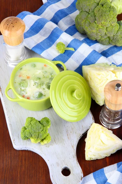 Капустный суп в тарелке на борту для разрезания возле салфетки на деревянном столе — стоковое фото
