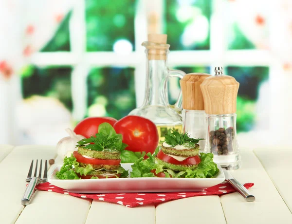 Вкусный жареный костный мозг и томатные ломтики с листьями салата, на ярком фоне — стоковое фото
