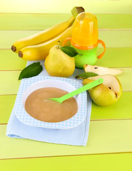 Saboroso purê de frutas do bebê e mamadeira na mesa de madeira — Fotografia de Stock