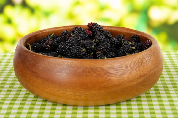 Ripe mulberries in bowl on table on bright background — Stock Photo, Image