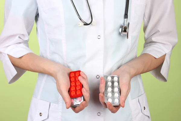 Primer plano de las píldoras de la mano del médico femenino, sobre fondo de color —  Fotos de Stock