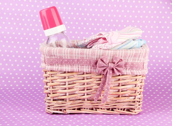 Beautiful basket of baby clothes on a pink background — Stock Photo, Image