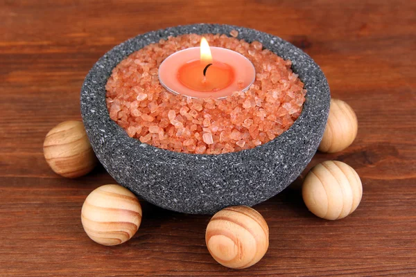 Candle in stone bowl with marine salt, on wooden background — Stock Photo, Image