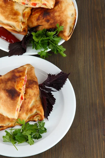 Pizzaschalen auf Tellern auf Holztisch — Stockfoto