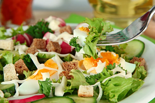 Salade fraîche mélangée avec des œufs, des feuilles de salade et d'autres légumes, sur fond lumineux — Photo