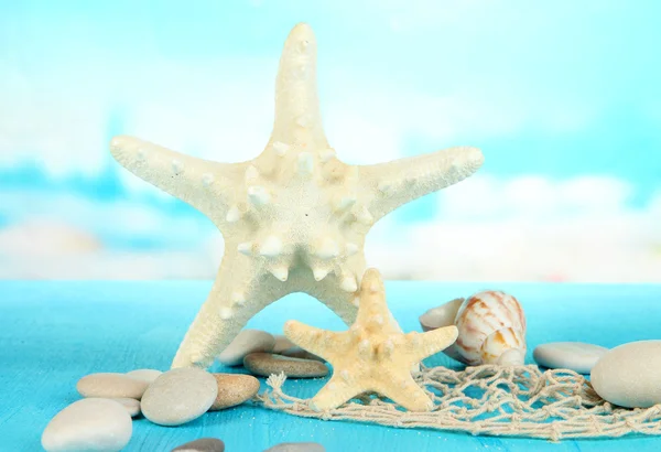 Rozgwiazdy biały na niebieskim drewnianym stole na tle morza — Zdjęcie stockowe