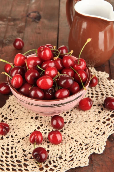 Zralé červené cherry bobule v misce na dřevěný stůl detail — Stock fotografie