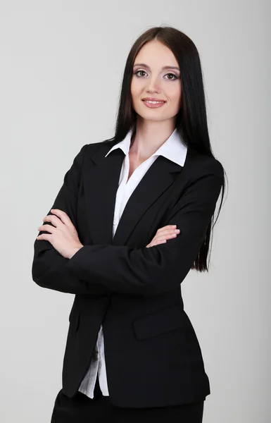 Giovane donna d'affari, su sfondo grigio — Foto Stock