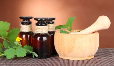 İlaç şişe masanın üzerinde kahverengi zemin üzerinde ile çiçeklenme kırlangıçotu