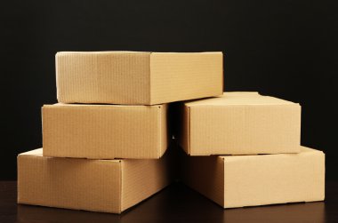 siyah arka plan üzerine ahşap masa üstünde parsel