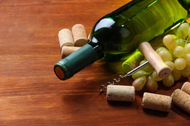 şişe şarap, üzüm ve ahşap zemin üzerinde mantarlar