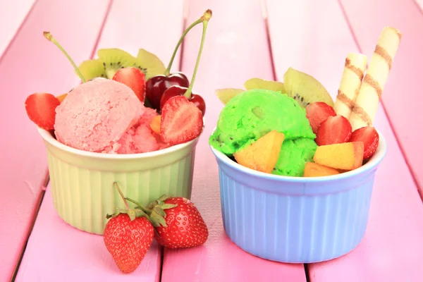 Leckeres Eis mit Früchten und Beeren in Schüssel auf Holztisch — Stockfoto