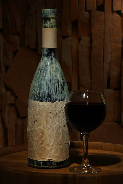 Kompozycja ze starą butelkę wina i lampka w starej piwnicy, na ciemnym tle — Zdjęcie stockowe