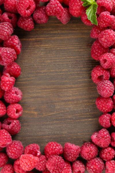 Framboises sucrées mûres sur fond de bois — Photo