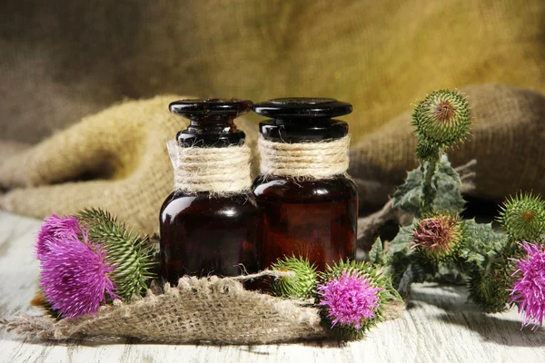 Medicine bottles with thistle flowers — Stock Photo, Image