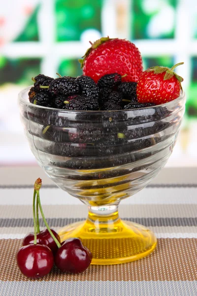 Moget mullbär med körsbär och jordgubbar i skål på bordet i rummet — Stockfoto