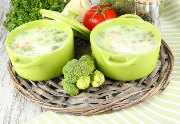 Kohlsuppe in Tellern auf geflochtenem Tablett auf Serviette auf Holztisch — Stockfoto