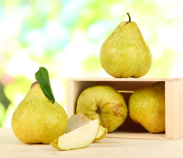 Pears in drawer on burlap on wooden table on nature background — Stock Photo, Image