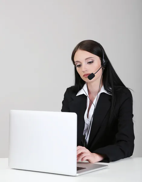 Operatore di call center al lavoro, su sfondo grigio — Foto Stock