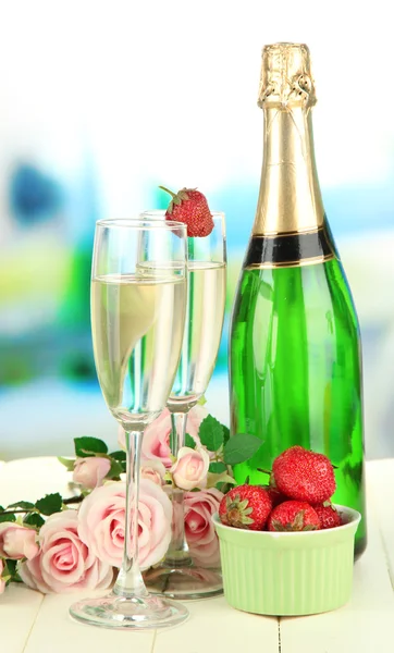 Romantische Stilleven met champagne, aardbei en roze rozen, op lichte achtergrond — Stockfoto
