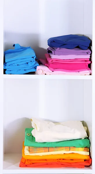 Clothes neatly folded on shelves — Stok fotoğraf