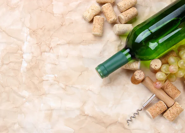 Bottle of wine, grapes and corks on old paper background — Stock Photo, Image