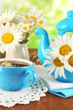 doğal zemin üzerine ahşap masa üzerinde çaydanlığın içinde güzel buket chamomiles