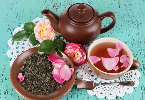 Wasserkocher und Tasse Tee aus Teerose an Bord auf Serviette auf Holzgrund — Stockfoto