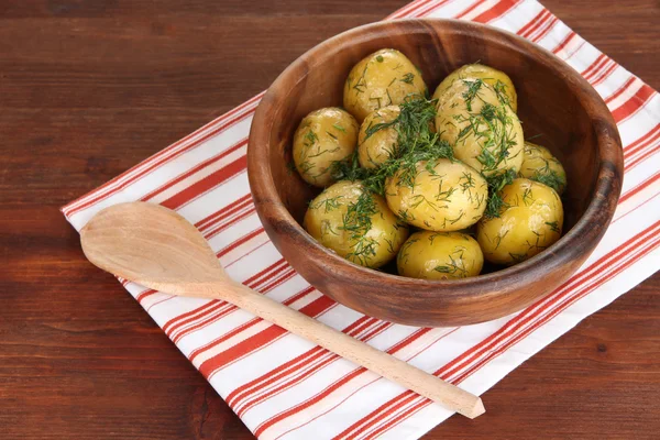 Boiled potatoes on wooden bowl on napkin on wooden table — Stock Photo, Image