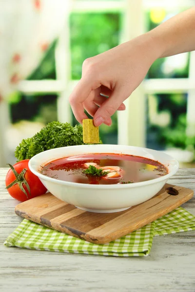 Kom soep met bouillon kubus op houten tafel — Stockfoto