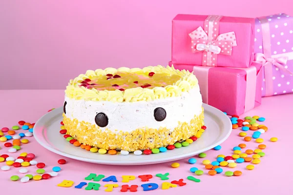 Bolo de aniversário feliz e presentes, no fundo rosa — Fotografia de Stock