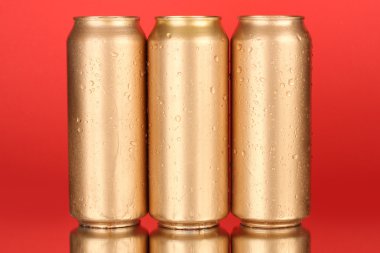 Renk arkaplanında su damlaları olan alüminyum kutular