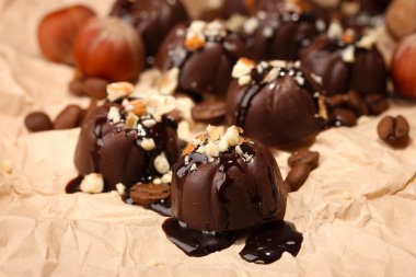 çikolata şekerleme ve bej renkli kağıt arka plan üzerinde kahve çekirdekleri