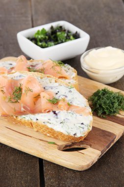 ahşap masa üzerinde kesme tahtası üzerinde balık sandviç