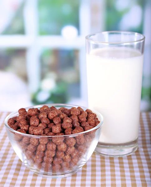 Delicioso y saludable cereal en tazón con leche en la mesa en la habitación — Foto de Stock