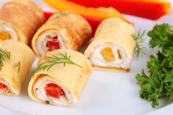 Rotoli d'uovo con crema di formaggio e paprika, su piatto, da vicino — Foto Stock