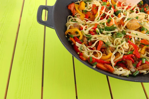 Macarrão com legumes em wok no fundo de madeira — Fotografia de Stock